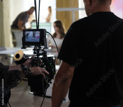 Behind the scenes of the camera when shooting a film, advertisement, video, team, actors. Shooting place, side view, focus on the hand with a raised finger