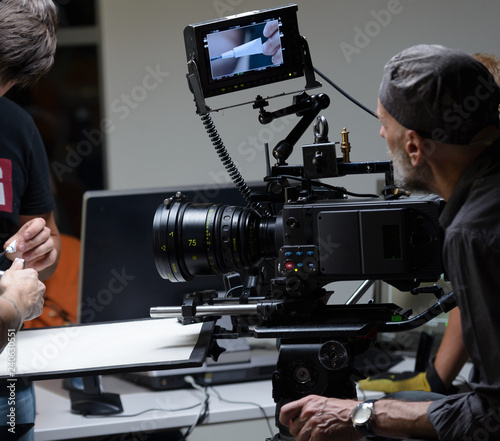 Behind the scenes of the camera when shooting a film, advertisement, video, team, actors. Shooting place, side view, focus on the hand with a raised finger