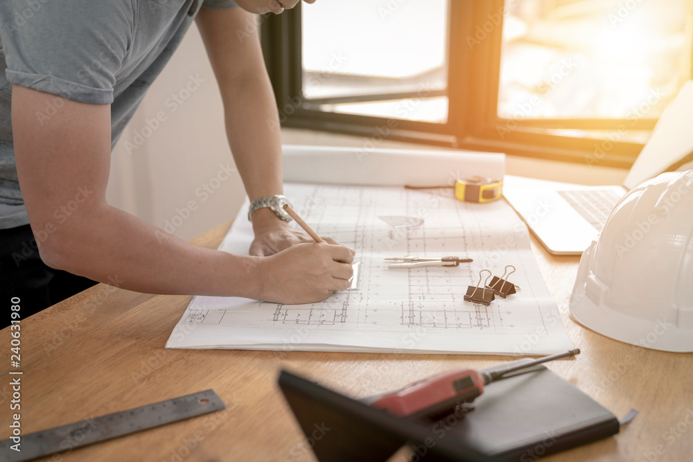 architect or civil engineer during drawing home or building in office on working table with office stationary , laptop ,color pallette sampling. architect or civil engineer during drawing home or building in office on working table with office stationary , laptop ,color pallette sampling.