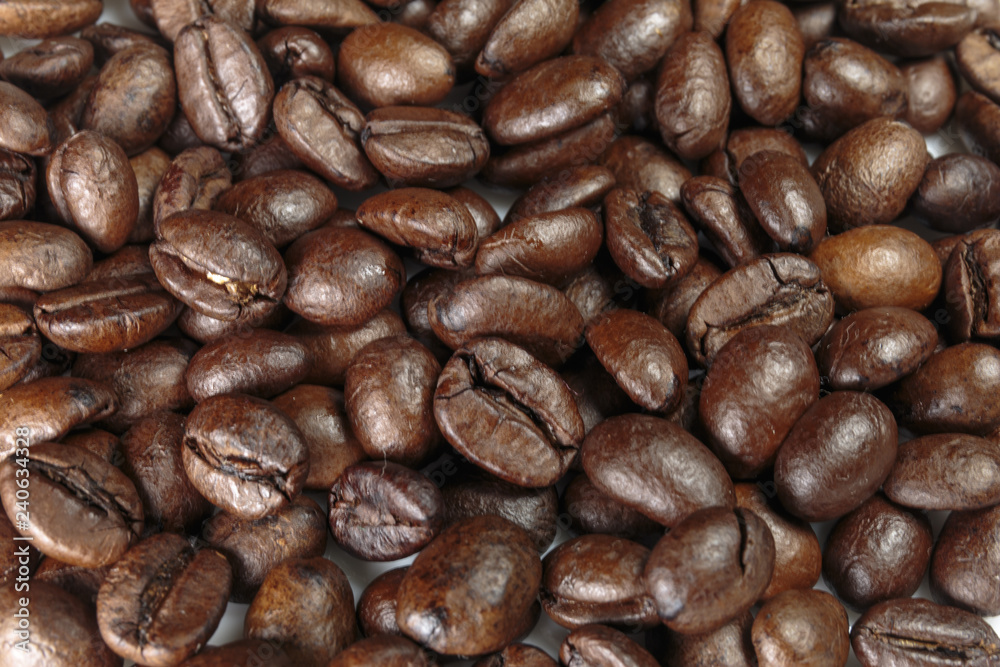 Well-roasted coffee beans background closeup.