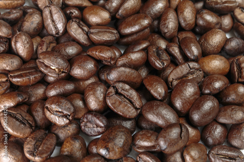 Well-roasted coffee beans background closeup.