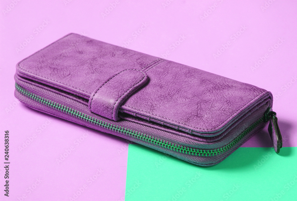 Purple leather purse close-up on a blue yellow pastel background. Purple leather purse close-up on a blue yellow pastel background.