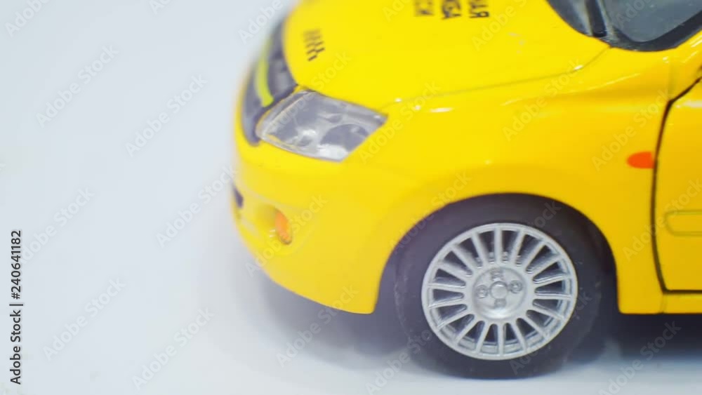 small toy yellow taxi car rides and stops.Close-up.Macro shot.business concept.Taxi.transportation of passengers. small toy yellow taxi car rides and stops.Close-up.Macro shot.business concept.Taxi.transportation of passengers.