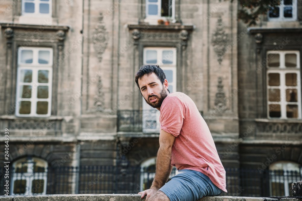 .Young man doing sightseeing around the beautiful city of Bordeaux in France. Feeling free and happy discovering new places. Travel photography.