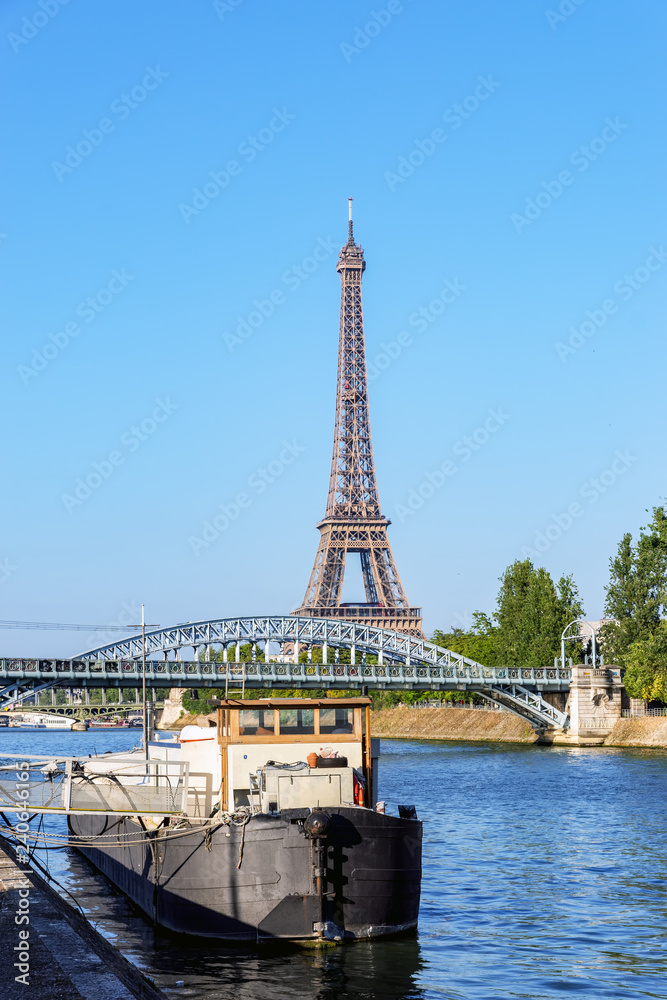 Old barge moored near Pont Rouelle on the seine with Eiffel tower in background - Paris, France. The Pont Rouelle is only a railway bridge and was constructed for the 1900 World Fair.