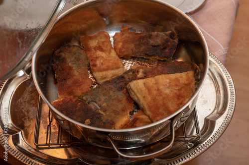 Tasty fried pieces of carp fish in a metal pot. Dishes prepared for the holidays.