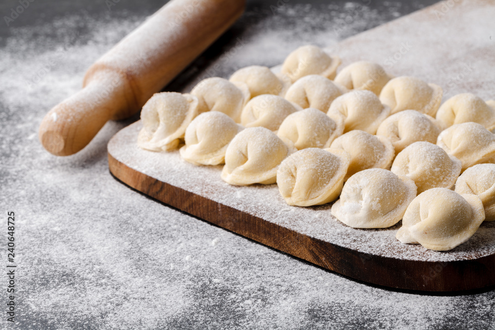 Raw frozen dumplings,pelmeni,ravioli on the board Raw frozen dumplings,pelmeni,ravioli on the board