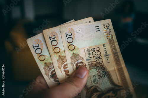 Hand holding Bolivian money