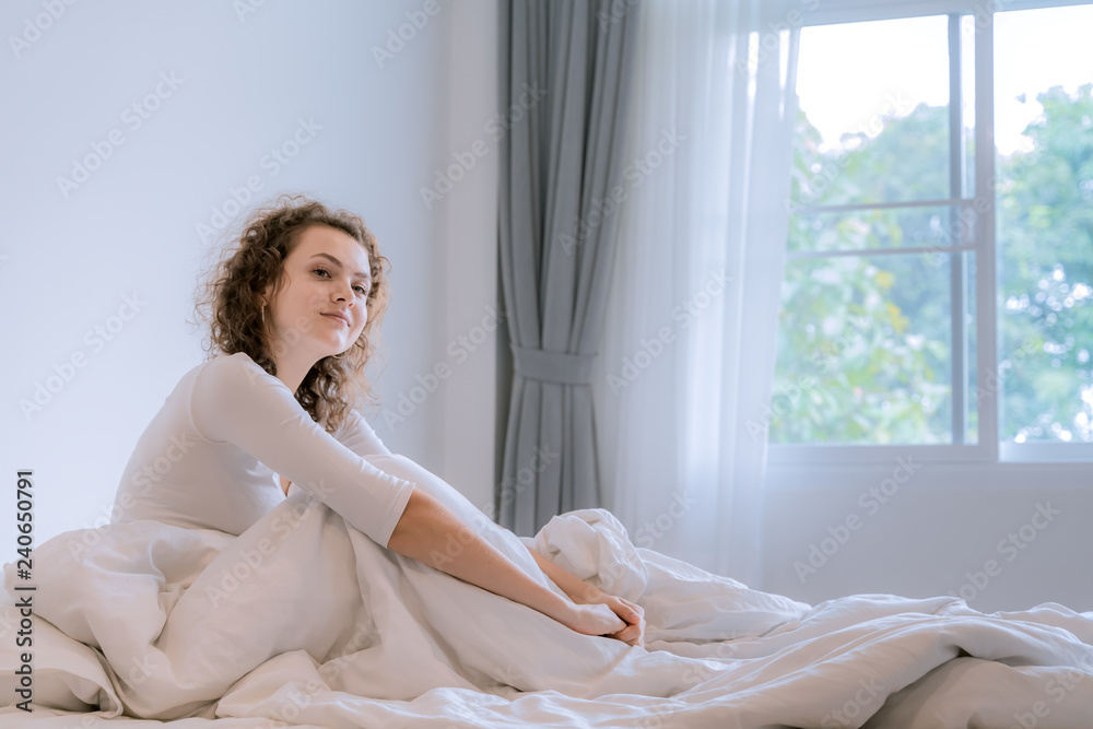 A beautiful European woman sitting in the bedroom in the morning, she woke up. A beautiful European woman sitting in the bedroom in the morning, she woke up.