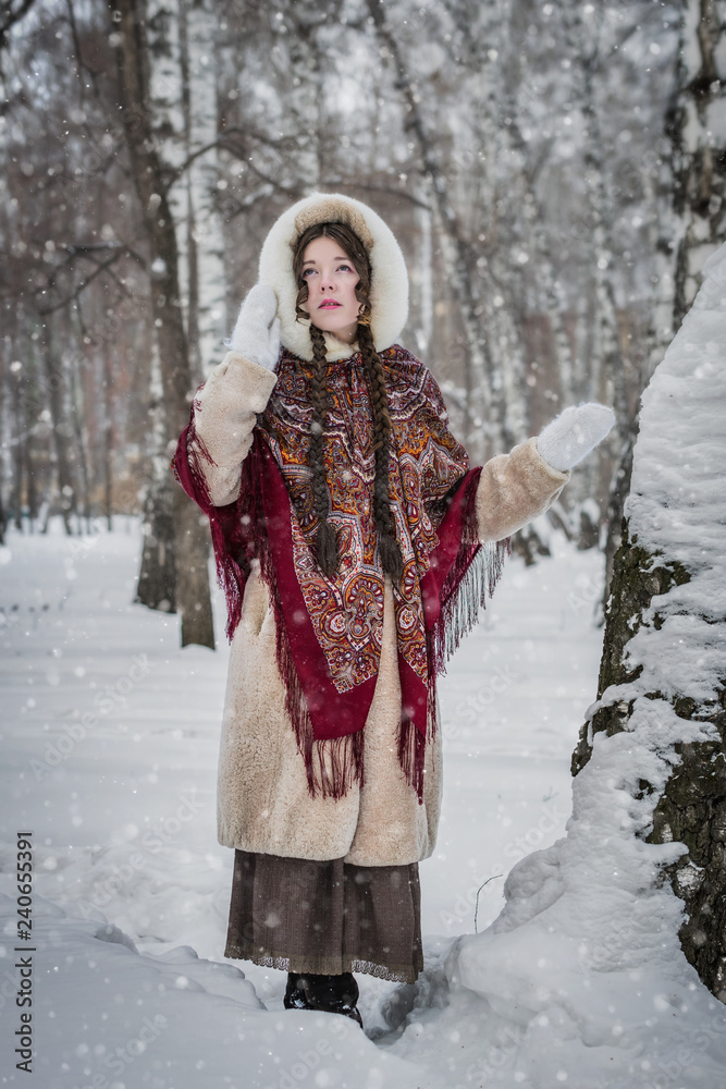 Woman in fur coat on a walk in park winter day Woman in fur coat on a walk in park winter day