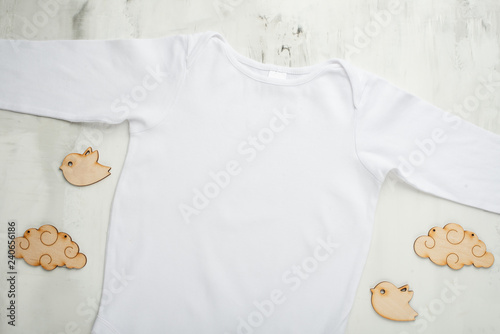 Layout Flat Lay white baby bodysuit shirt, on a white background with children's wooden toys. Mock up for design and placement of logos, advertisements © Anton