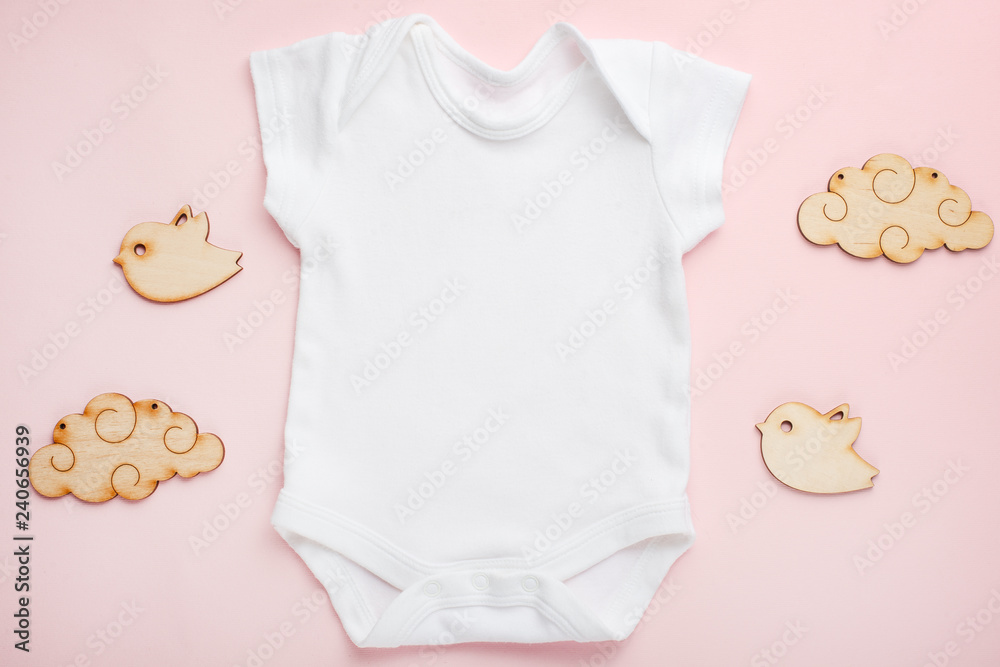 Layout Flat Lay white baby bodysuit shirt, on a pink background, for a girl with wooden toys. Mock up for design and placement of logos, advertisements Layout Flat Lay white baby bodysuit shirt, on a pink background, for a girl with wooden toys. Mock up for design and placement of logos, advertisements