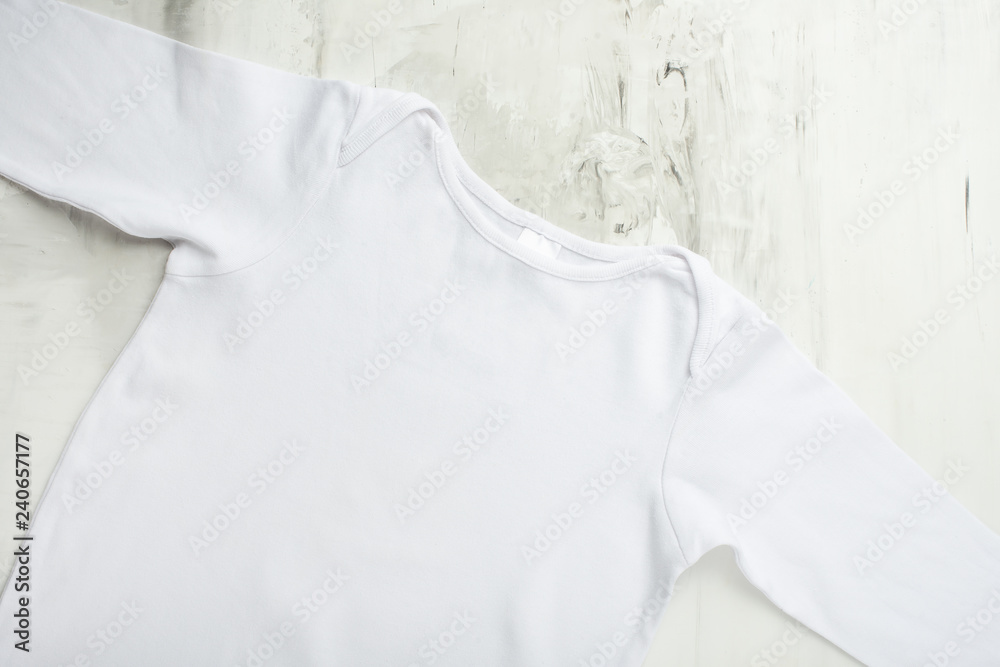 Mock up baby, detskaya white t-shirt on a light background.Flat-lay Mock up baby, detskaya white t-shirt on a light background.Flat-lay