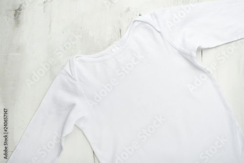 Mock up baby, detskaya white t-shirt on a light background.Flat-lay © Anton