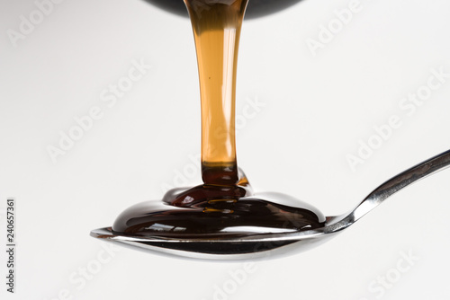 Pouring Dark Corn Syrup on a Spoon