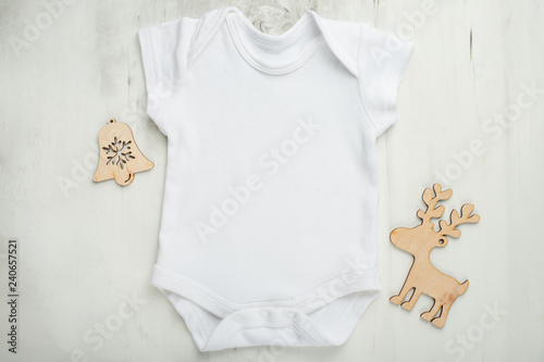 Layout Flat Lay white baby bodysuit shirt, on a white background with children's wooden toys. Mock up for design and placement of logos, advertisements © Anton