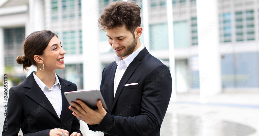 Couple of business people using a tablet outdoor Couple of business people using a tablet outdoor