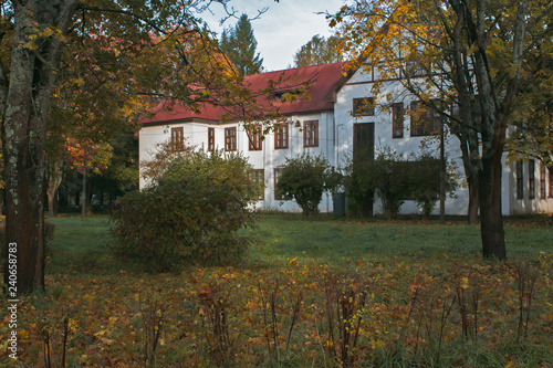 two-story white house in park in autumn