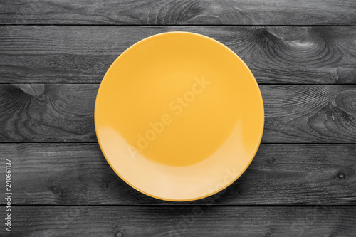 Empty yellow plate on woode...