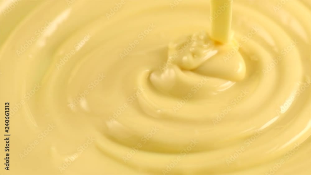 White molten chocolate. Pouring melted liquid premium white chocolate. Confectionery. Slow motion. 3840X2160 4K UHD video footage White molten chocolate. Pouring melted liquid premium white chocolate. Confectionery. Slow motion. 3840X2160 4K UHD video footage