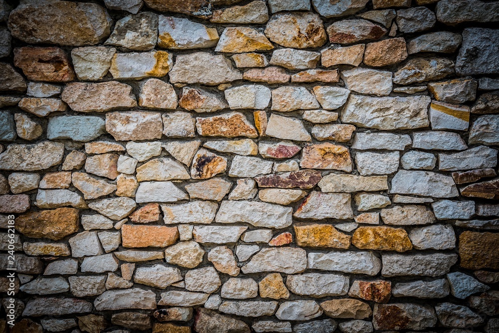 Stone wall background of colorful stones with HDR effect and vignetted borders
