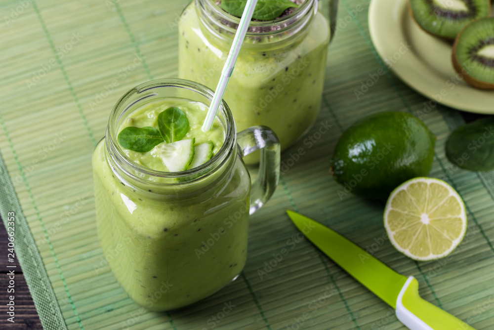 Green smoothie on green background made by avocado, lemon and kiwi. Green smoothie on green background made by avocado, lemon and kiwi.
