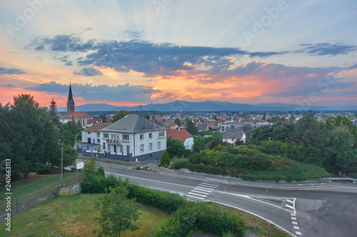 Panoramic view on settlement in Alsace,France,road and Vosges mountain at sundown.Roofs of the city from top.Beautiful landscape/Beautiful view of church and red roofs of small town in Alsace