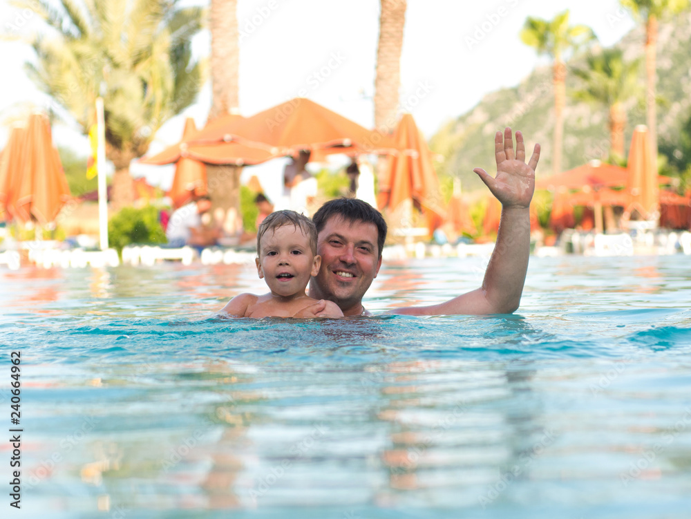 Father and child swimming in the pool