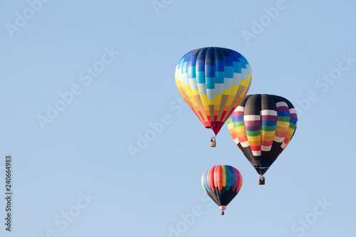 Multi colored hot air balloon flying over blue sky