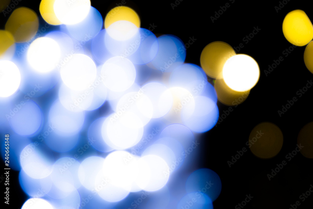 Abstract blurred blue and yellow circles on dark background.