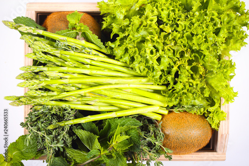 спаржа зелень и разные фрукты и овощи лежат на столе 