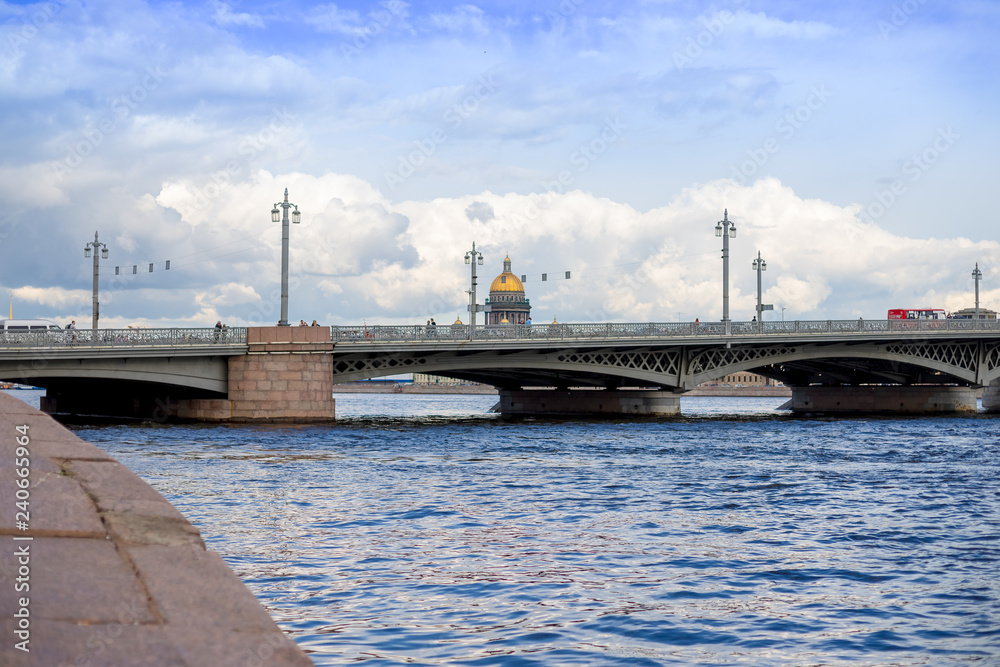 View of the summer city with cloudly sky. In the foreground Blagoveshchensky bridge in St. Petersburg. In the background, the main attractions. the Palace Bridge and St. Isaac sobo. Russia, Saint