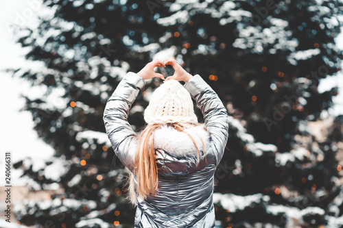 girl on the background of the Christmas tree shows the heart