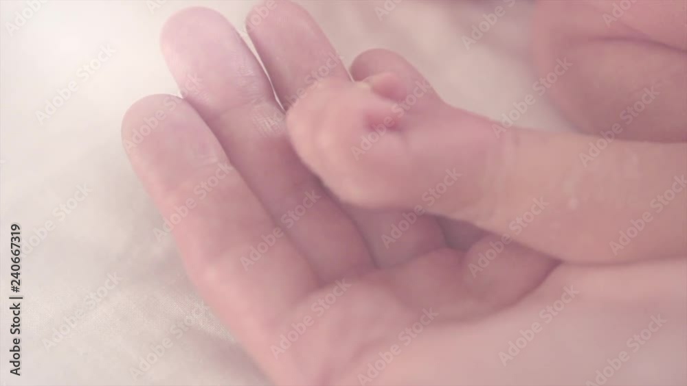 Tiny newborn baby's hand in female hand closeup. Baby hand in mother palm. Happy family concept. Slow motion. 3840X2160 4K UHD video footage Tiny newborn baby's hand in female hand closeup. Baby hand in mother palm. Happy family concept. Slow motion. 3840X2160 4K UHD video footage