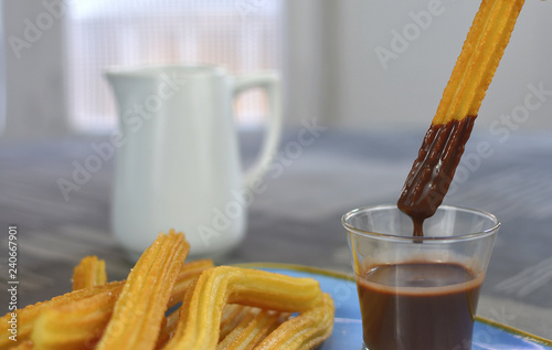 Churros with a cup of hot chocolate closeup, selective focus. - Image