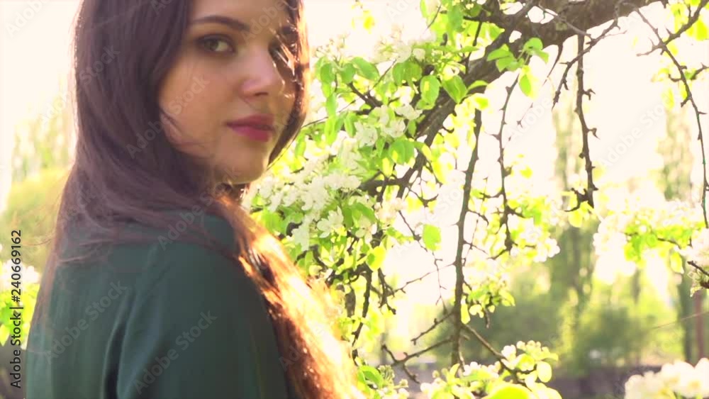 Beauty young woman enjoying nature in spring apple orchard. Happy beautiful girl in garden with blooming trees. Slow motion 4K UHD video footage. 3840X2160 Beauty young woman enjoying nature in spring apple orchard. Happy beautiful girl in garden with blooming trees. Slow motion 4K UHD video footage. 3840X2160