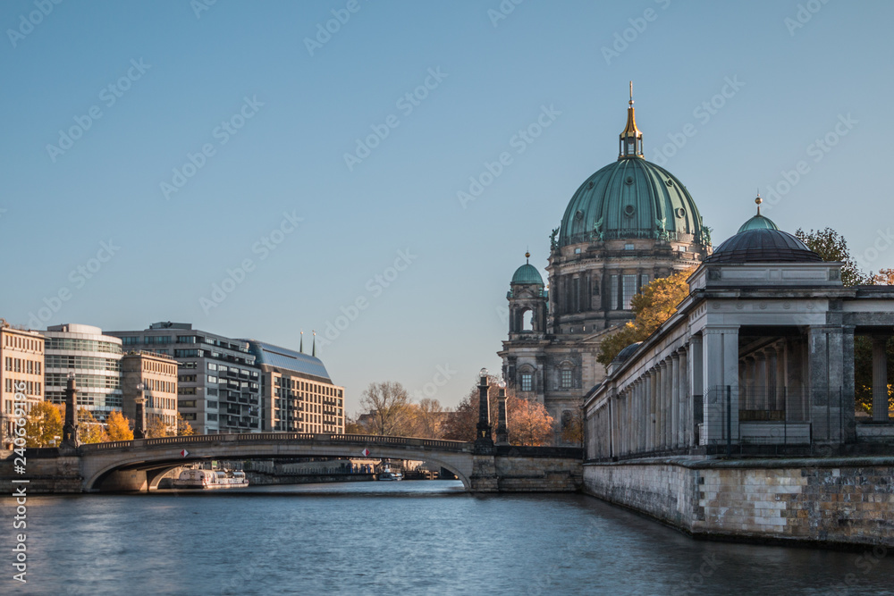 Berlin Cathedral with Friedrichs Bridge over the River Spree. Historic arcade of the National Gallery. Sunny day at blue sky and buildings at the Spree shore