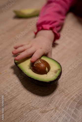 Children's hand reaches for the avocado. healthy food for children