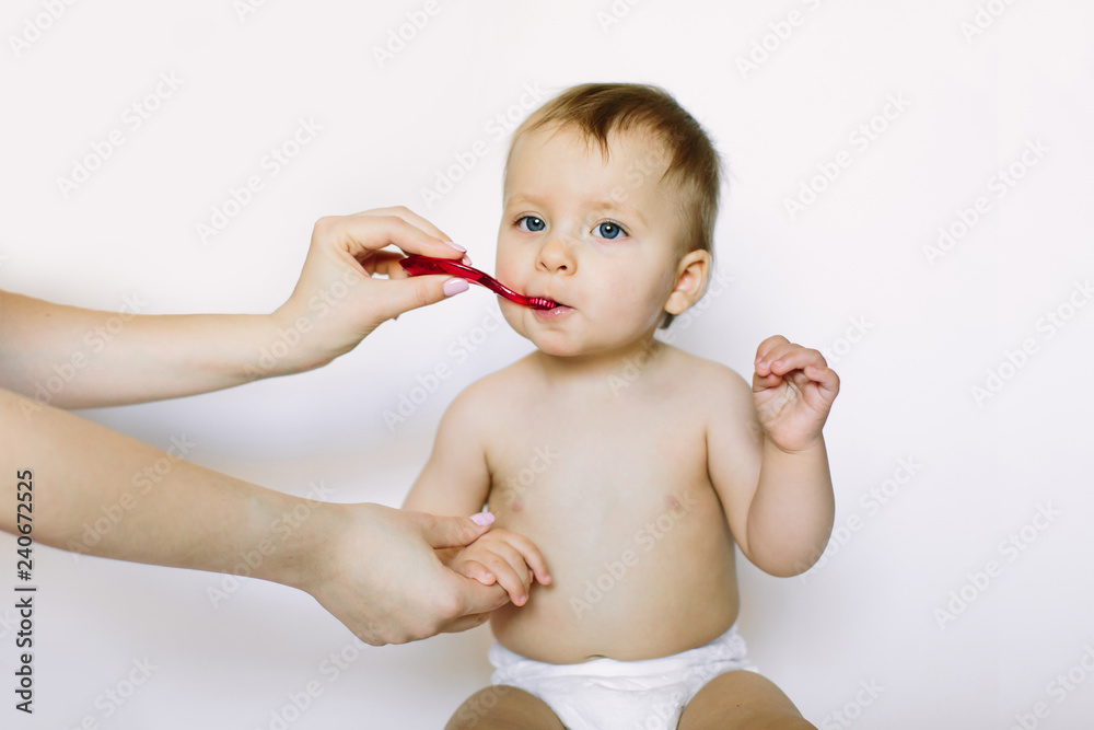 Infant with toothbrush. Mother teaching baby girl teeth brushing Infant with toothbrush. Mother teaching baby girl teeth brushing