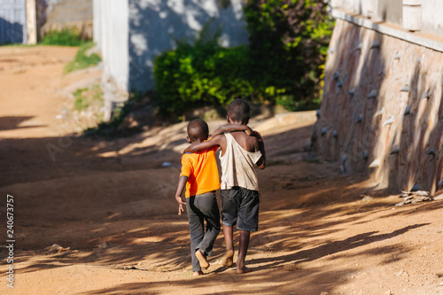 boys walking arm in arm in Uganda, Africa photo