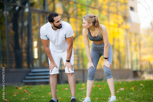 Fototapeta Naklejka Na Ścianę i Meble -  Fitness. Personal Trainer Takes Notes While Woman Exercising Outdoor