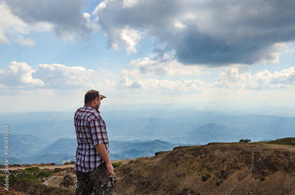 Man dressed for hiking observing landscape from top of Kopaonik mountain, Serbia