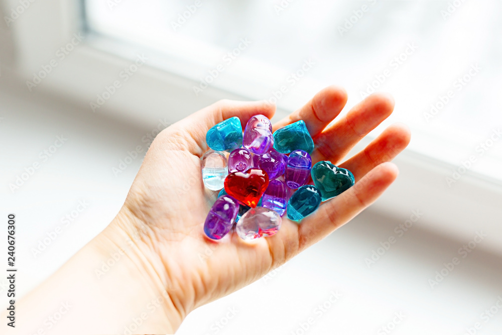 Some small colorful plastic hearts in a hand on daylight. Symbol of love and care. Some small colorful plastic hearts in a hand on daylight. Symbol of love and care.