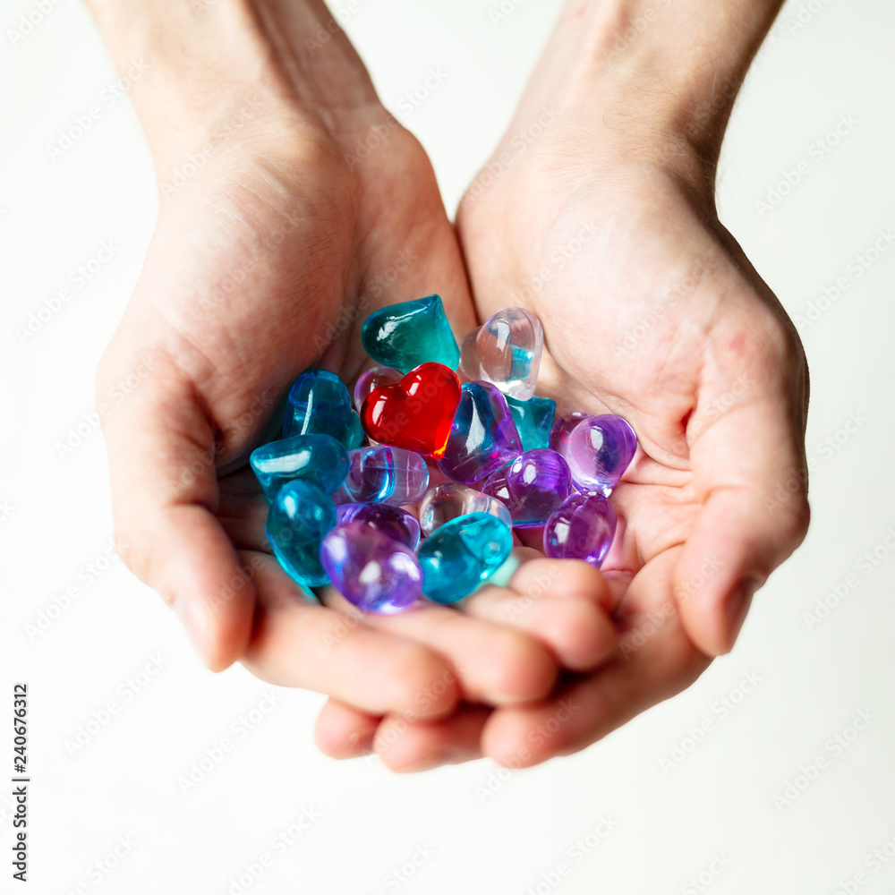 Some small colorful plastic hearts in a hand on daylight. Symbol of love and care. Some small colorful plastic hearts in a hand on daylight. Symbol of love and care.