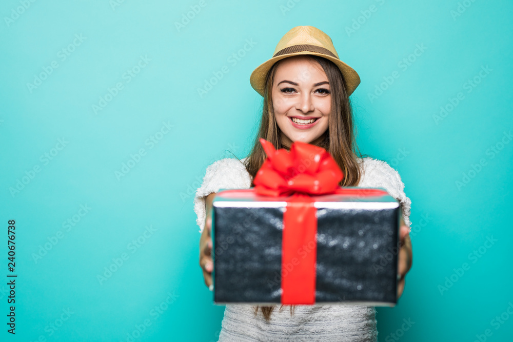 Portrait of smiling pretty girl holding gift box isolated over blue background Portrait of smiling pretty girl holding gift box isolated over blue background