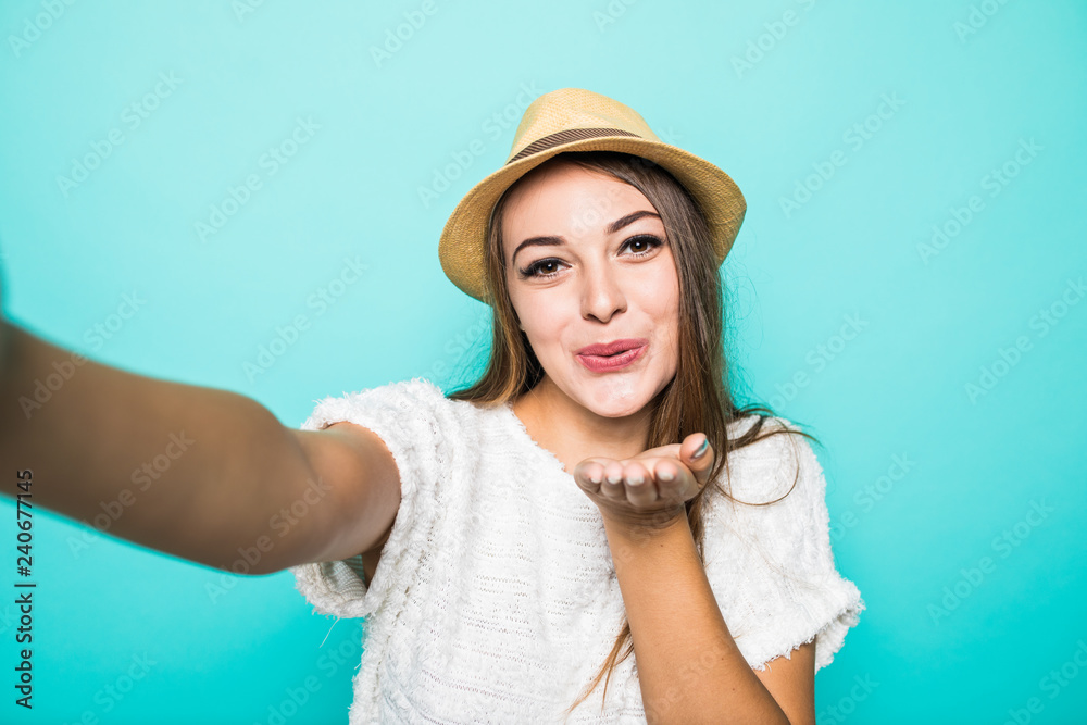 Portrait of a young woman taking a selfie isolated over blue background Portrait of a young woman taking a selfie isolated over blue background
