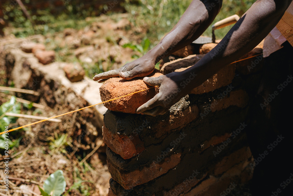 man in Uganda buidling a house man in Uganda buidling a house
