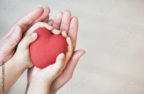 people  age  family  love and health care concept - close up of adult woman and child hands holding red heart over lights background. 