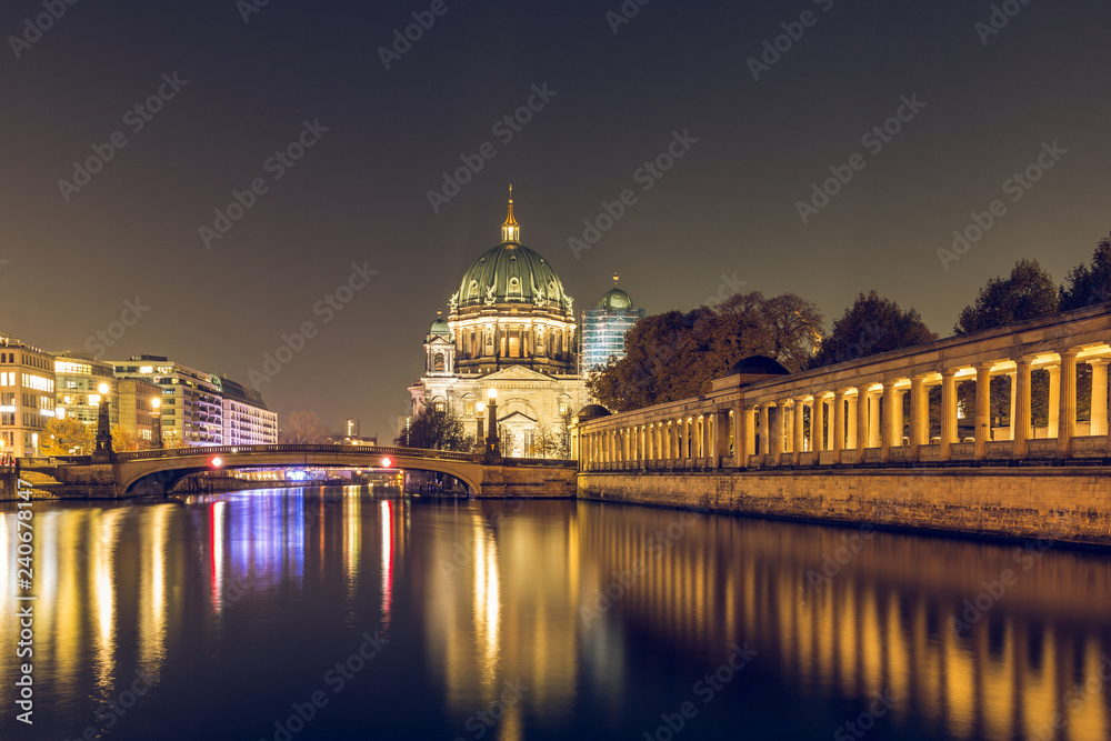 Berlin Cathedral at night with the Friedrichs Bridge. On the river Spree reflect the lights. The illuminated pillar gallery on the Spree shore