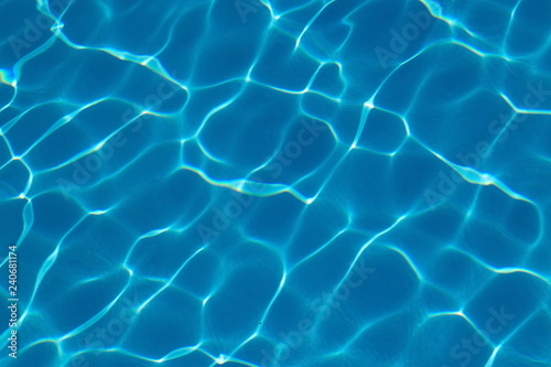  Rippled pattern of blue clean water in a  swimming pool. © Ruslans